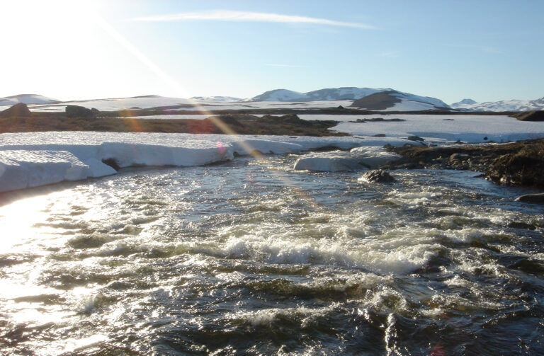 View of snow-capped mountains and water's edge