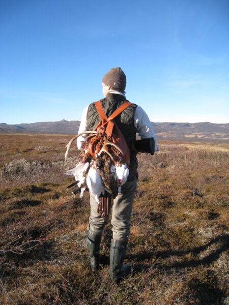 A hunter with prey on his back